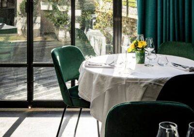 Tables intérieures LVR avec mur en marbre et chaises en velours vert